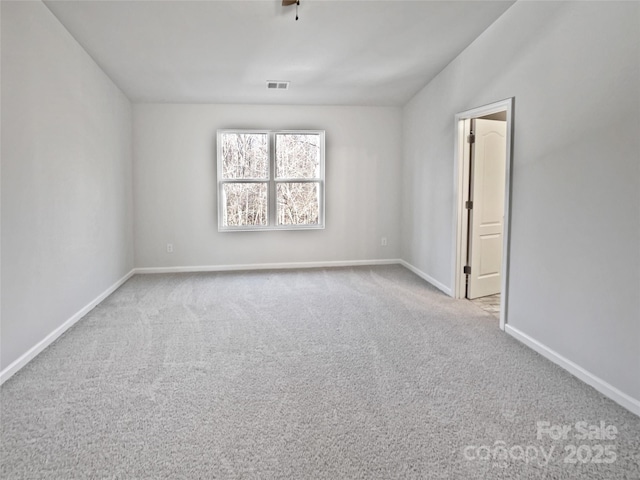 carpeted empty room featuring visible vents and baseboards