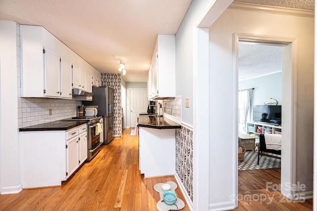 kitchen featuring appliances with stainless steel finishes, dark countertops, white cabinetry, and light wood finished floors