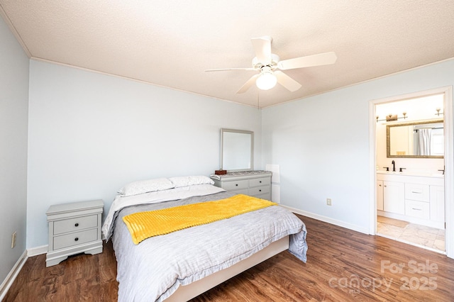 bedroom with dark wood-style flooring, a textured ceiling, and baseboards