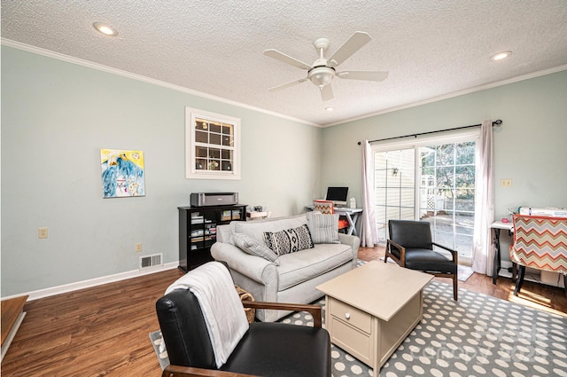 living room featuring baseboards, visible vents, ceiling fan, ornamental molding, and wood finished floors