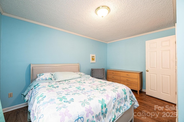 bedroom featuring ornamental molding, dark wood-style flooring, a textured ceiling, and baseboards