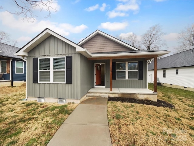 view of front of house with covered porch, board and batten siding, and a front yard