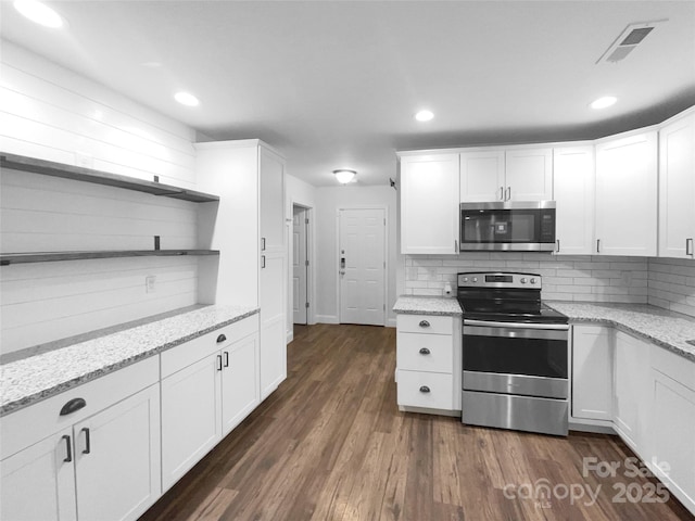 kitchen with dark wood-style flooring, open shelves, stainless steel appliances, visible vents, and white cabinetry