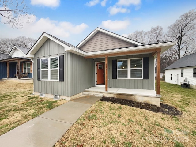 view of front of property with a porch, a front lawn, and central air condition unit