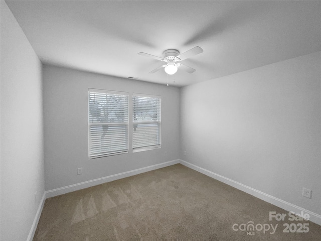 spare room with carpet floors, baseboards, and a ceiling fan