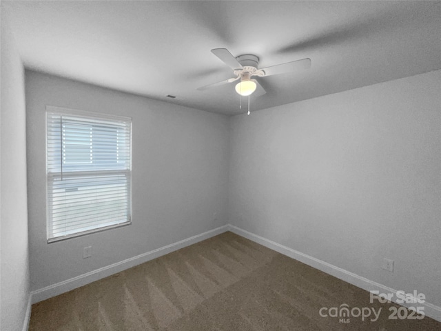 spare room featuring carpet, a ceiling fan, and baseboards