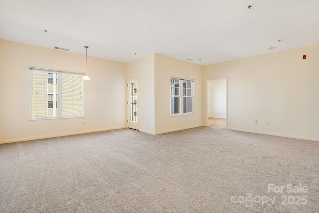 spare room featuring carpet flooring, visible vents, and baseboards