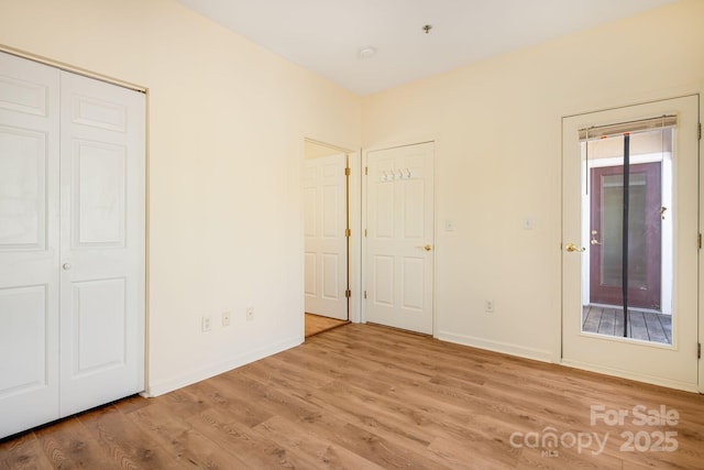 unfurnished bedroom with wood finished floors and baseboards