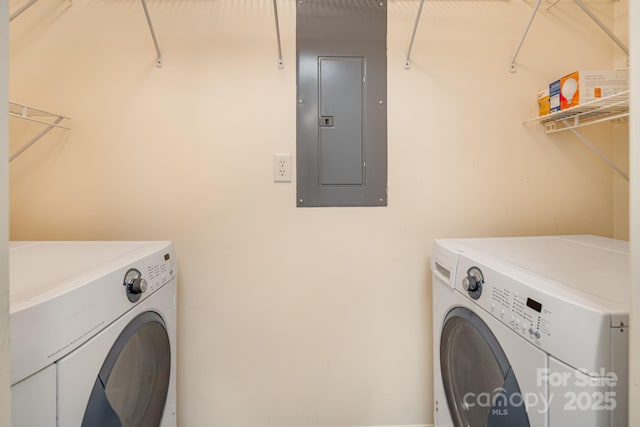 laundry area featuring laundry area, electric panel, and washing machine and clothes dryer