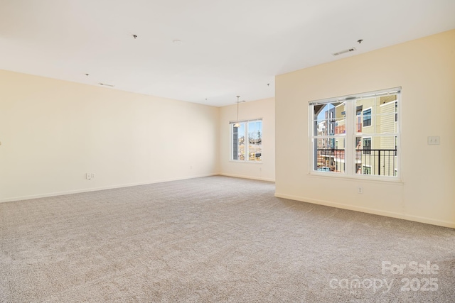 carpeted spare room featuring visible vents and baseboards