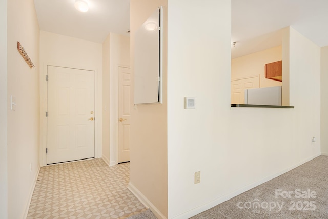 hallway featuring carpet floors and baseboards