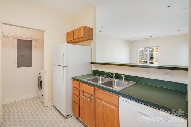 kitchen with white appliances, electric panel, dark countertops, separate washer and dryer, and a sink