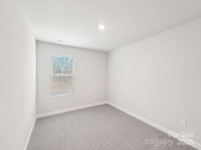 carpeted empty room with visible vents and baseboards