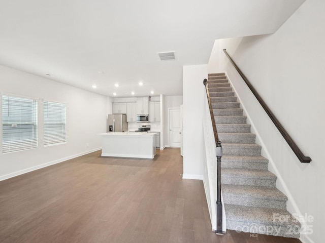 interior space with recessed lighting, visible vents, baseboards, and wood finished floors