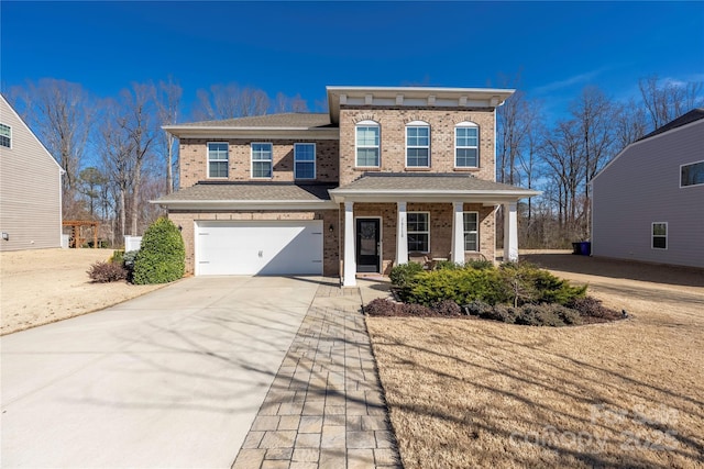 view of front of house with covered porch, concrete driveway, brick siding, and an attached garage