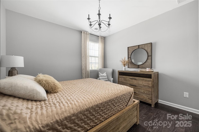 bedroom with a notable chandelier, dark wood finished floors, and baseboards