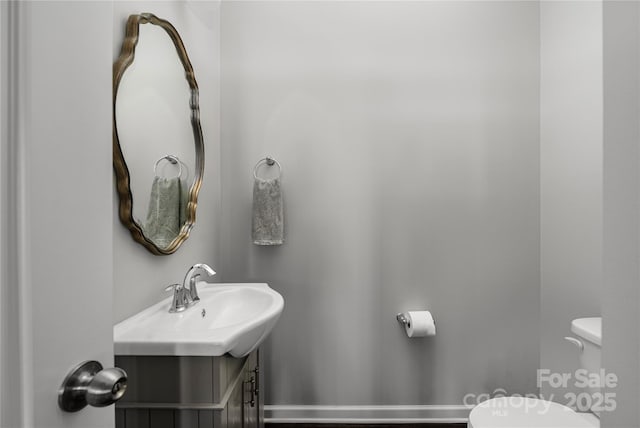 half bathroom with vanity and toilet