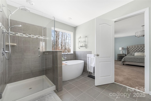 full bathroom with a stall shower, a soaking tub, ensuite bath, tile patterned flooring, and tile walls