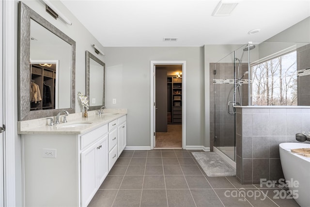 full bath featuring visible vents, a sink, and a shower stall