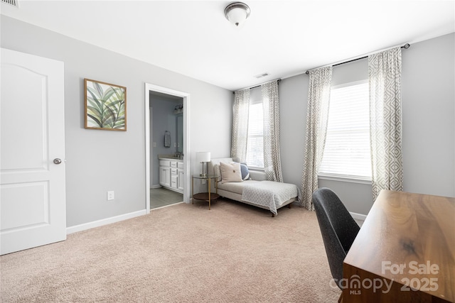 carpeted bedroom featuring ensuite bath, baseboards, and visible vents