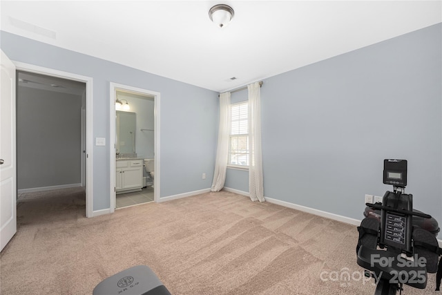 unfurnished bedroom with light carpet, ensuite bath, and baseboards