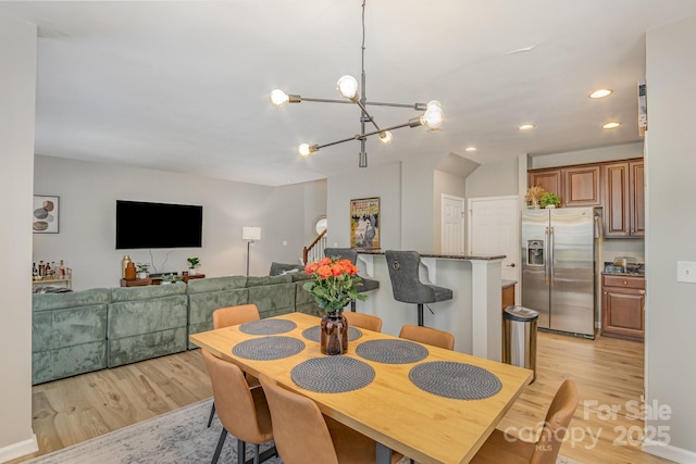 dining room with stairs, light wood-type flooring, an inviting chandelier, and recessed lighting