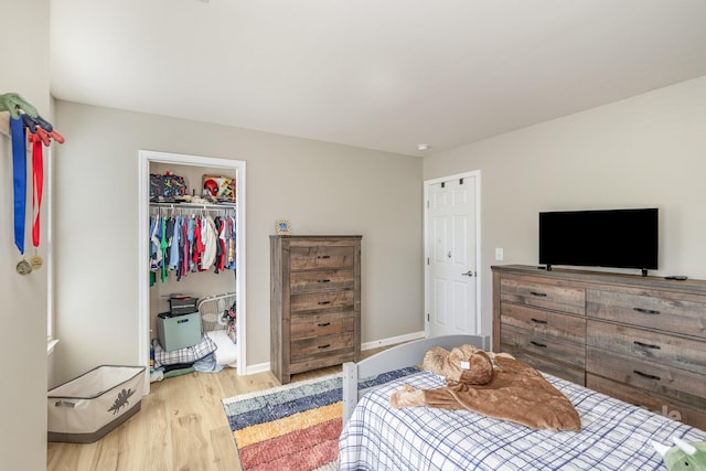 bedroom with a closet, baseboards, and wood finished floors