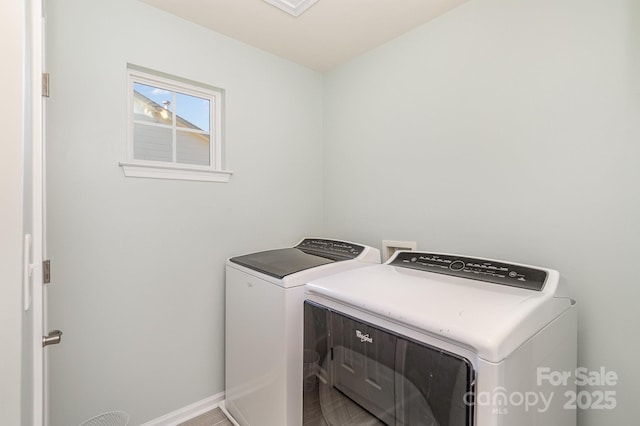 clothes washing area featuring laundry area, independent washer and dryer, and baseboards