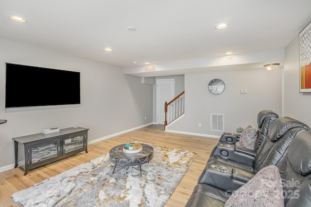 living area with recessed lighting, visible vents, stairway, and wood finished floors