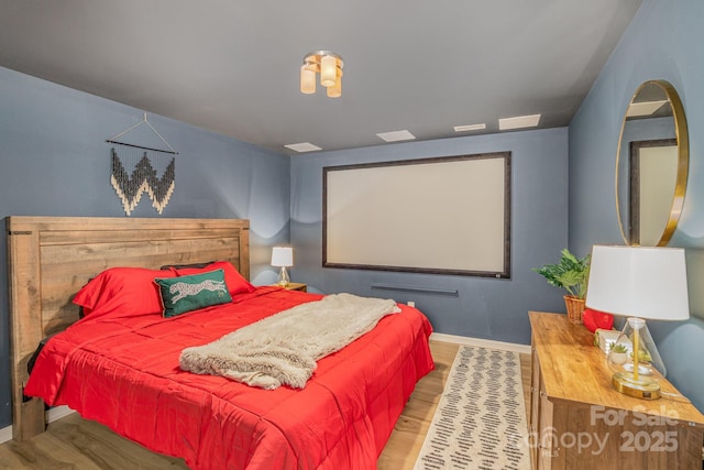 bedroom featuring baseboards and wood finished floors