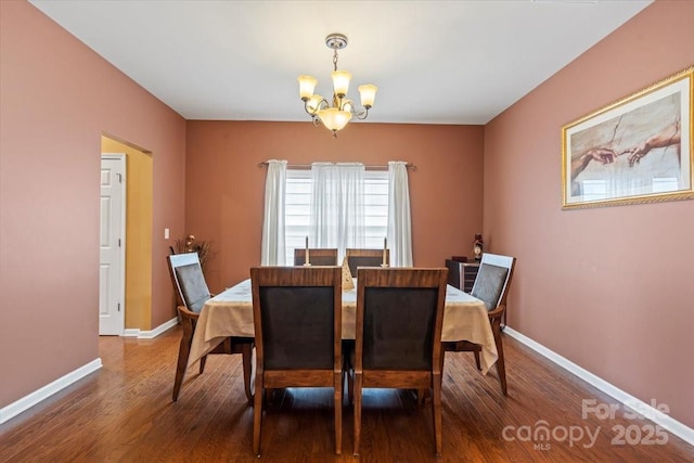 dining room with wood finished floors, baseboards, and a chandelier