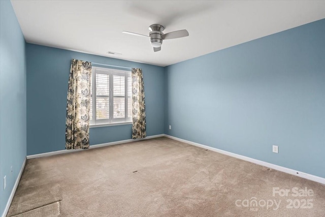 carpeted empty room featuring visible vents, baseboards, and ceiling fan