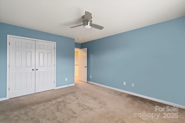 unfurnished bedroom featuring a closet, baseboards, ceiling fan, and carpet flooring