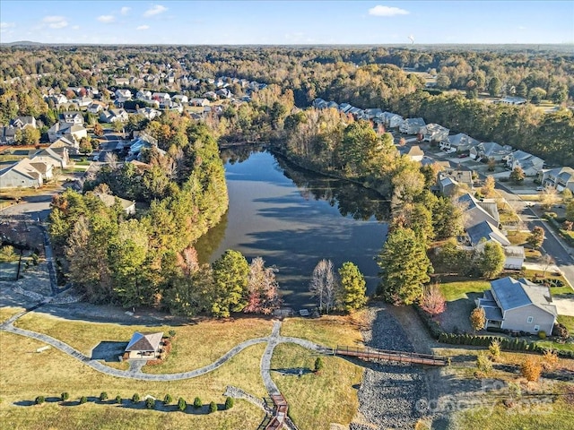 birds eye view of property featuring a wooded view, a water view, and a residential view