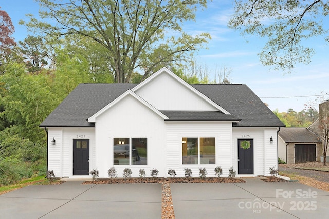 modern farmhouse style home with a shingled roof