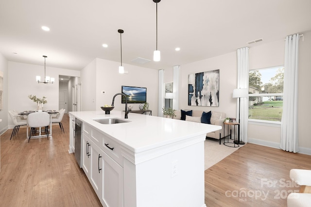 kitchen featuring light wood-style floors, visible vents, white cabinets, and a sink