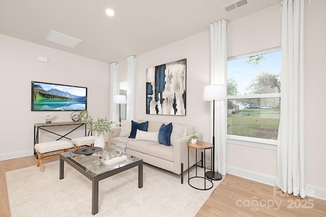 living room featuring recessed lighting, visible vents, light wood-style flooring, and baseboards