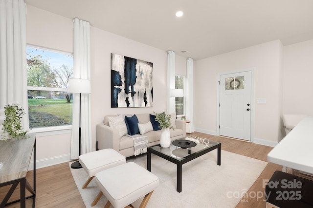 living area with light wood finished floors, recessed lighting, and baseboards