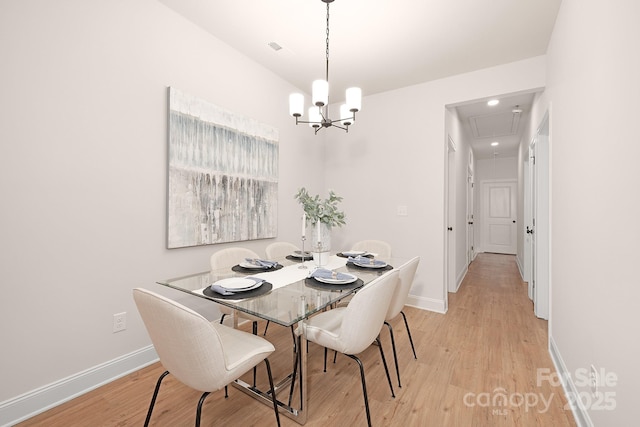 dining area featuring visible vents, an inviting chandelier, light wood-style floors, attic access, and baseboards