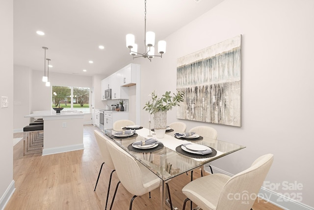 dining room with recessed lighting, baseboards, a notable chandelier, and light wood finished floors