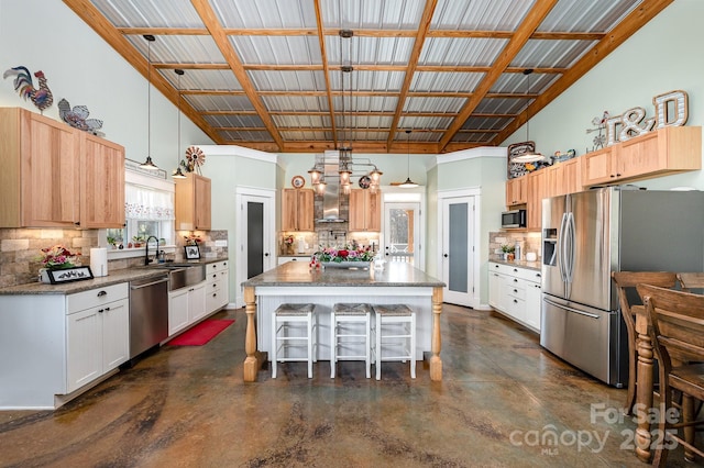 kitchen featuring stainless steel appliances, a center island, white cabinets, and hanging light fixtures