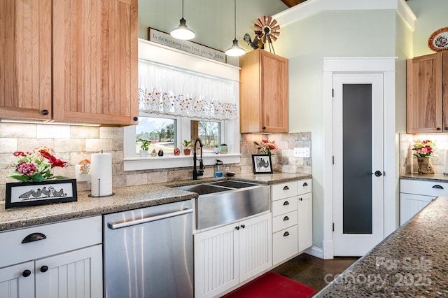 kitchen with a sink, white cabinetry, stainless steel dishwasher, and decorative light fixtures