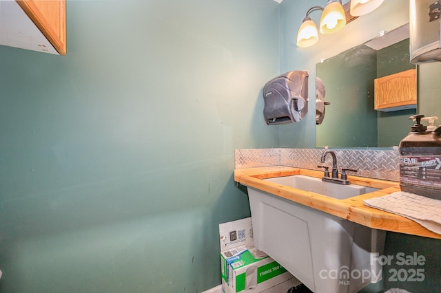 bathroom featuring decorative backsplash and a sink