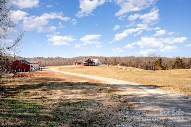 view of street with driveway and a rural view