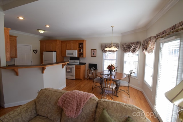 dining room featuring light wood-type flooring, baseboards, a chandelier, and a wealth of natural light