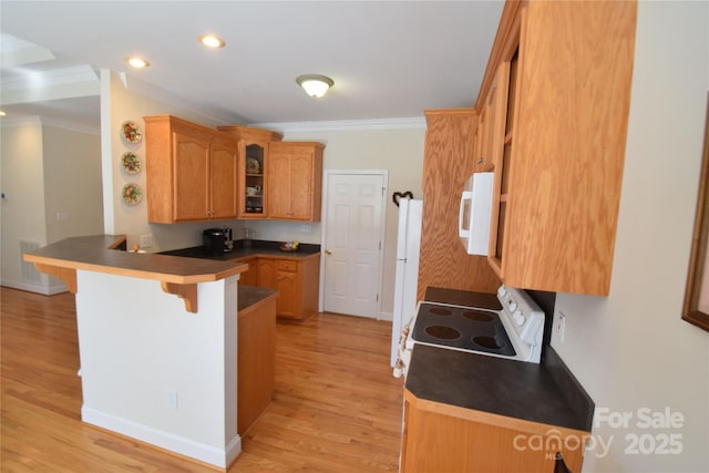 kitchen with ornamental molding, a peninsula, white appliances, and a kitchen bar