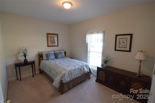 bedroom with light colored carpet and baseboards