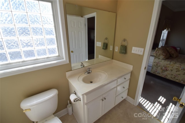 ensuite bathroom featuring toilet, tile patterned flooring, connected bathroom, and vanity