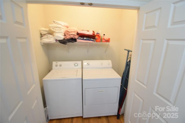 laundry room with laundry area, independent washer and dryer, and light wood finished floors