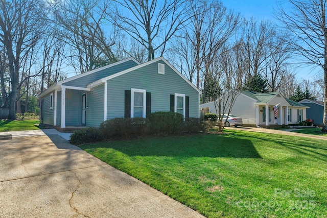 view of side of home featuring concrete driveway and a lawn